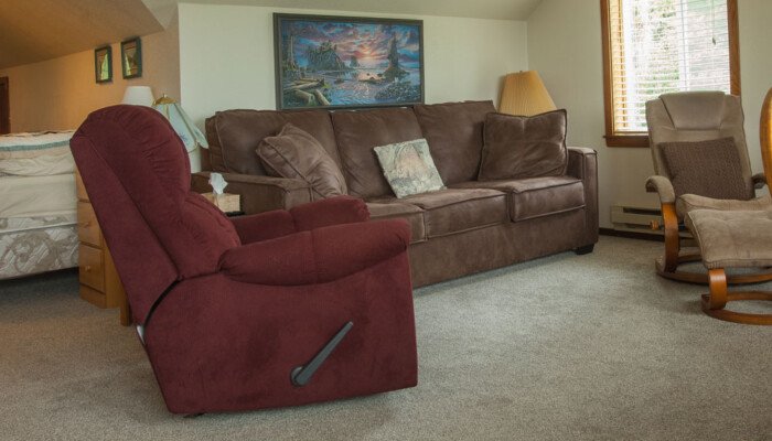 Cozy living room with sofa, chairs, and wall artwork.