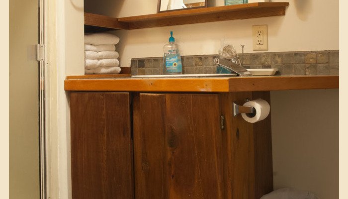 Wooden bathroom vanity with mirror and stacked towels