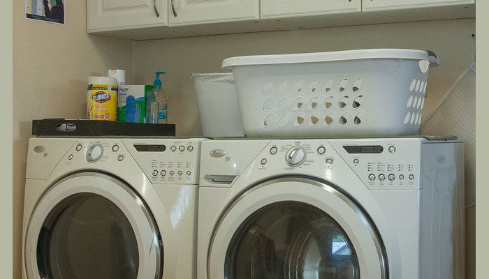 Laundry room with washer, dryer, and cleaning supplies