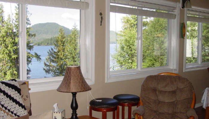 Cozy lakeside room with forest view through open windows