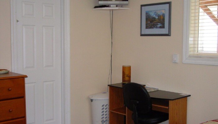 Cozy home office with desk, chair, and mounted TV