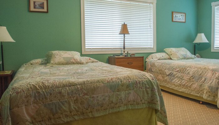 Two twin beds in a cozy, well-lit bedroom